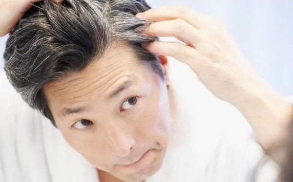 Man looking at greying hair and Greyverse to solve it